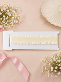 pretmybaby cream ruffled elastic baby headband on a white display card with decorative flowers