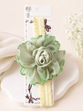pretmybaby pastel green chiffon flower baby headband with ruffled edges on a soft yellow elastic band
