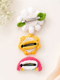 pretmybaby set of three handmade crochet hairclips featuring a white flower, yellow flower, and pink rainbow design.