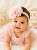 pretmybaby baby girl wearing a soft pastel pink headband with a large fluffy layered flower for special occasions