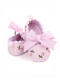 pretmybaby pink baby bellies featuring delicate floral embroidery and a decorative striped bow on a soft fabric base