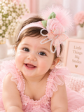 pretmybaby infant wearing a pastel pink headband with a layered rose, butterfly, and feathers for special occasions