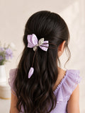 pretmybaby pastel lilac organza tulip hairclip with a dangling bud on a bow, worn by a young girl