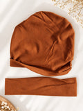 pretmybaby newborn baby gift set featuring a soft rust-brown turban cap and a matching stretchy baby headband