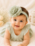 pretmybaby infant wearing a soft sage green headband with a large layered fluffy flower for special occasions