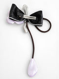 pretmybaby hairclip featuring a black bow, pastel organza tulip flower, and a dangling bud on a white background