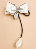 pretmybaby hairclip featuring a white organza tulip bow with a dangling bud on a metal alligator clip
