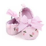 Pret my baby Embroidery bellies with stripe bow – pink: Pink baby shoes with floral embroidery, large striped bows, scalloped edges, non-slip soles, and a pink-white striped lining. Shown side by side on a white background.