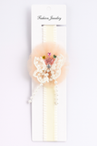 The Pret my baby Fancy fascinator crown on lace doilies baby headband is adorned with a lace butterfly, pink tulle, and colorful gems with pearls. Perfect for accessorizing infant outfits, it comes displayed on a white Fashion Jewelry card.