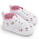 Pret my baby Embroidery Sneakers - White are adorable baby shoes featuring pink floral embroidery, pink scalloped trim, white laces, a pink lining, and soft soles—perfect pre-walker sneakers for little ones on the move.