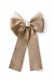 The pretmebabe Checkered Bow with trail Hair Clip features wide, long tails in brown and white houndstooth, accented by a cream top layer for classic glamour, styled against a white background.