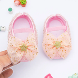 The Pret my baby Rosette bellies with star in pink feature large sheer peach bows and gold glittery stars—these adorable shoes make a perfect baby gift.