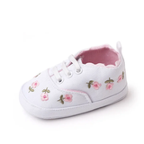 The Pret my baby Embroidery sneakers in white are pre-walker shoes with pink lining and floral embroidery featuring pink flowers and green stems—ideal for those looking for charming baby floral shoes.