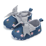 The Pret my baby Embroidery bellies with stripe bow - blue feature pink floral embroidery, black-and-white striped ribbon bows, a soft non-slip sole, and heel pull tabs for easy wear.