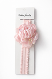 The Partywear fascinator large rose baby headband by Pret my baby features a pink chiffon rose on a white base, ideal for decorating baby headbands or adding a charming touch to infant accessories.
