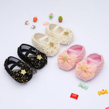 Three pairs of Pret my baby Rosette bellies with star—sparkly black, white, and pink infant shoes—are displayed in a row among toys and candy, making an ideal baby gift on a white background.