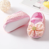Pret my baby Rosette bellies with star - pink: Adorable pink baby shoes featuring a large tulle bow, gold star, and delicate white and gold accents—ideal for a charming baby gift—shown on a white surface.
