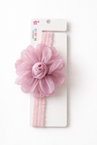 A pink fabric Fascinator extra large flower with rose bud baby headband, ideal for babies or toddlers, displayed on white packaging featuring the "Pret my baby" brand name.