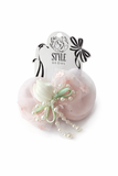 The Pret my baby Tulle curve bow with tulip and pearl ingrain fascinator hairclip features pink tulle, pearls, a white fabric flower, and green ribbon—ideal for fans of stylish satin tulip hair clips.