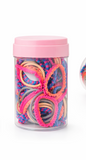 A clear plastic jar with a pink lid from Pret my baby holds 100 everyday mix hair ties in pink, yellow, orange, blue, and multicolored shades, displayed against a white background.